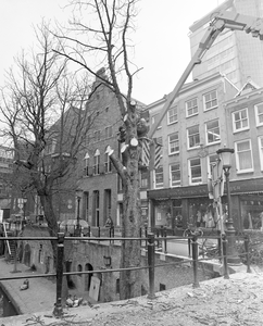 882332 Afbeelding van het kappen van een boom op de werf aan de oostzijde van de Oudegracht, bij de Jansbrug te Utrecht